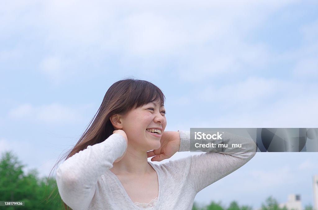 Asian woman combing her hair Young Asian woman combing her long hair. Japanese Ethnicity Stock Photo