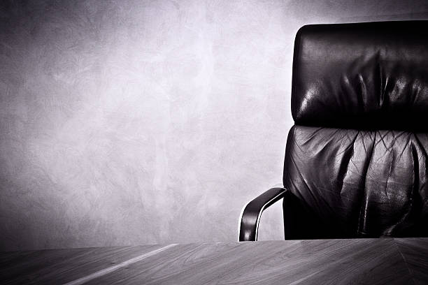 Old business great  Success- Leather chair and desk Laether office chair with wood table and Venecian painting wall. Some grain added. office chair stock pictures, royalty-free photos & images