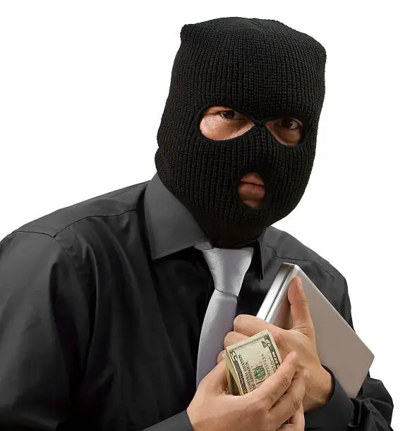 Company worker stealing money and a laptop isolated on white.