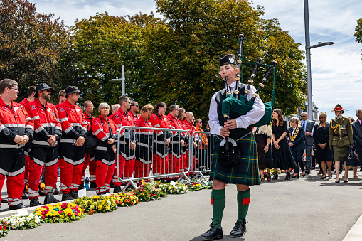 FILE - 22 February 2021, Christchurch, New Zealand. A bagpiper leads dignitaries at the national memorial service marking the 10th anniversary of the Canterbury earthquakes. Prime Minister Jacinda Ardern is seen in the background as the procession passes members of the civil defence force.