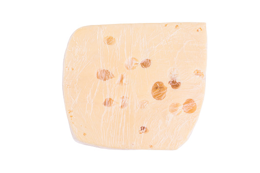 Piece of cheese with holes in cellophane film isolated on white background