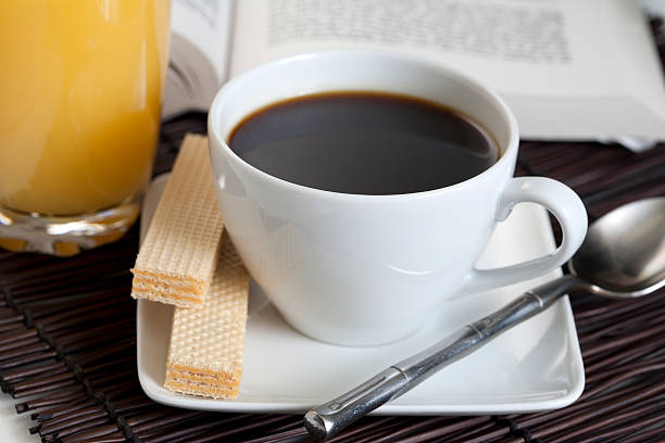 Śniadanie z soku pomarańczowego, kawę podczas czytania książki – zdjęcie