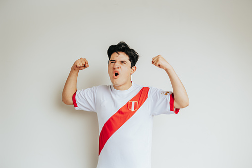 Young boy celebrates a goal or the victory of his team, the Peruvian soccer team. Celebrate qualifying for the World Cup or winning a bet.