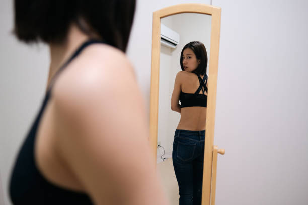 istock Young woman looking at herself by mirror 1381901565