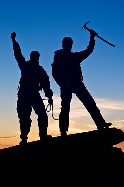 istock Silhouette of two climbers with hands up 138190272