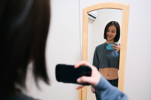 Young woman taking selfie in front of the mirror