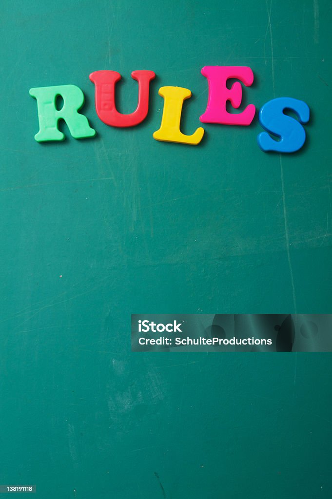 Rules on a Chalkboard Rules spelled out with preschool letters on a chalkboard with copy space. Authority Stock Photo