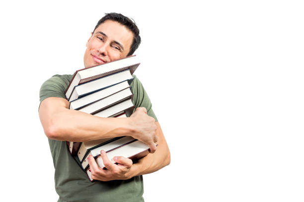 istock Pleased man embracing books and looking at camera 1381925710