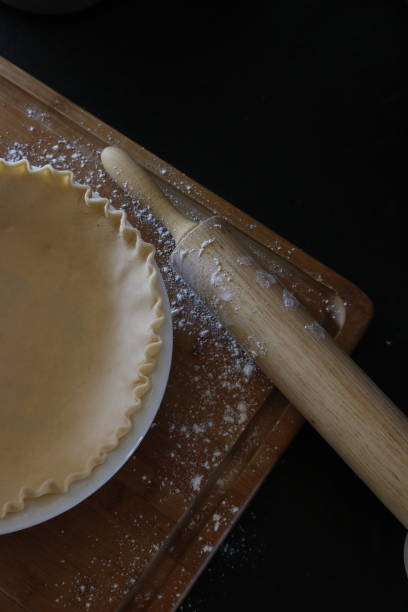 istock Raw pie shell in a pie plate with a rolling pin covered in flour 1381960997