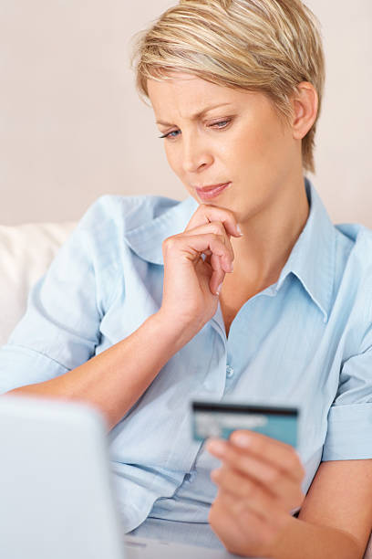 istock Thoughtful woman shopping online using a credit card 138196825