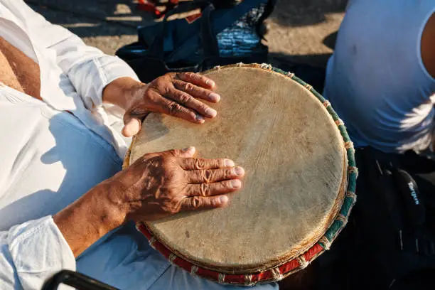 Hands of an African American man playing percussion with djembe drum bongo