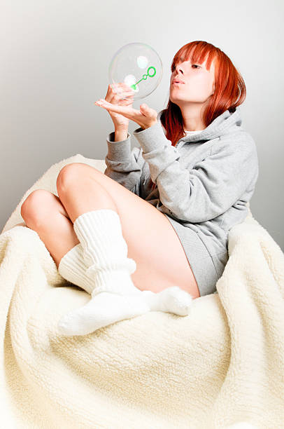 Pretty girl making soap bubbles stock photo