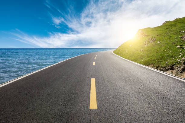 Empty asphalt road and mountain with sea natural scenery under blue sky