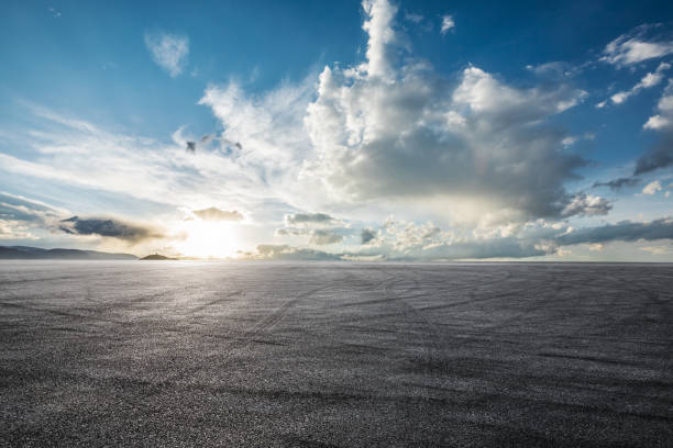 istock Asphalt road and blue sky with white clouds 1381989704
