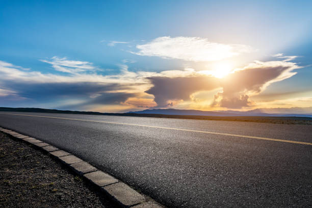 istock Asphalt road with sky clouds at sunset 1381991238