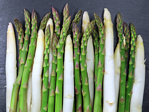 fresh white and green asparagus on slate plate background, spring season vegetable.
