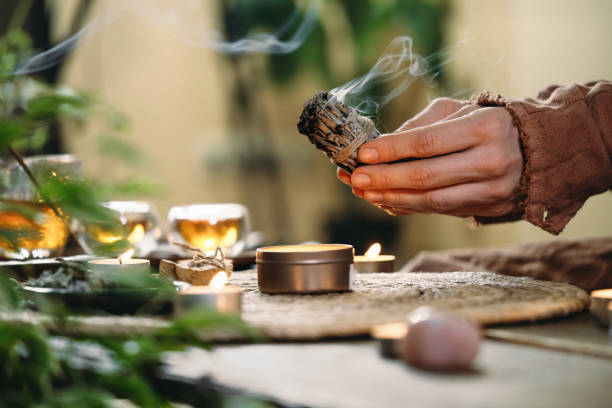 Woman hands burning white sage, before ritual on cadle