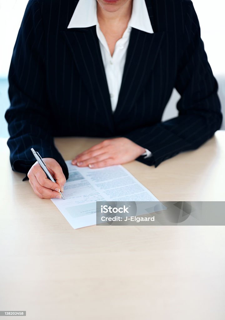 Imprenditore riempimento di un documento nella tabella - Foto stock royalty-free di Abbigliamento da lavoro