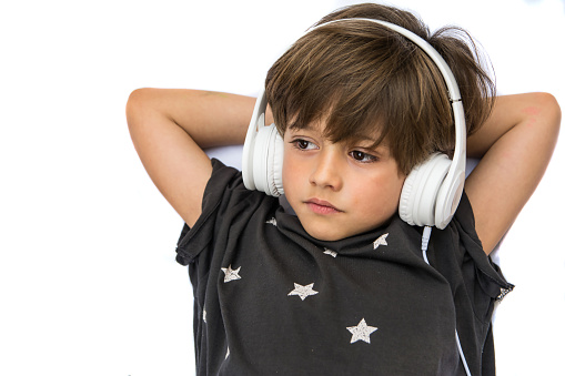 Cute Young Boy Listening To Music Wearing Headphones.Little Boy With Funny Gesture And Sunglasses.
Close-up Of A Beautiful Relaxed Child Listening To Music. White Background. Image With Copy Space