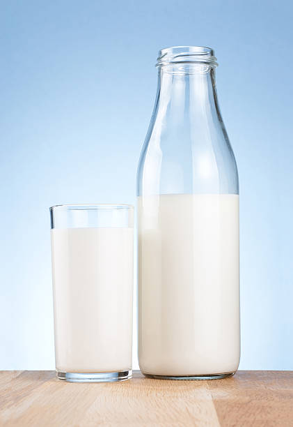 istock Half Milk bottle and glass on a blue background 138203858