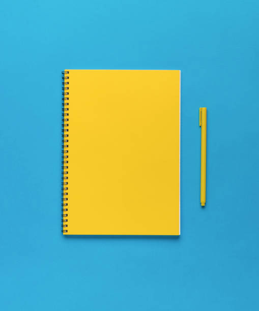 istock Yellow pen and yellow notebook on a blue background. Flat lay. 1382044346
