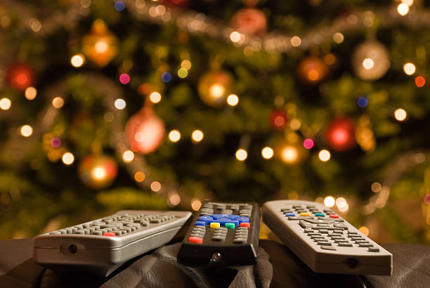 controles remotos en frente de iluminación del árbol de navidad - holiday healthy lifestyle weight christmas fotografías e imágenes de stock
