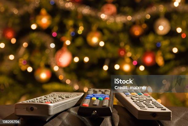 Remote Controls In Front Of Lit Christmas Tree Stock Photo - Download Image Now - Christmas, Television Set, Remote Control
