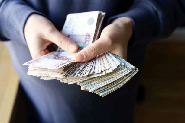 istock Russian rubles banknotes in hands during the war in Ukraine. Inflation, sanctions and the fall of the Russian economy concept. Falling cash savings and budget 1382059955