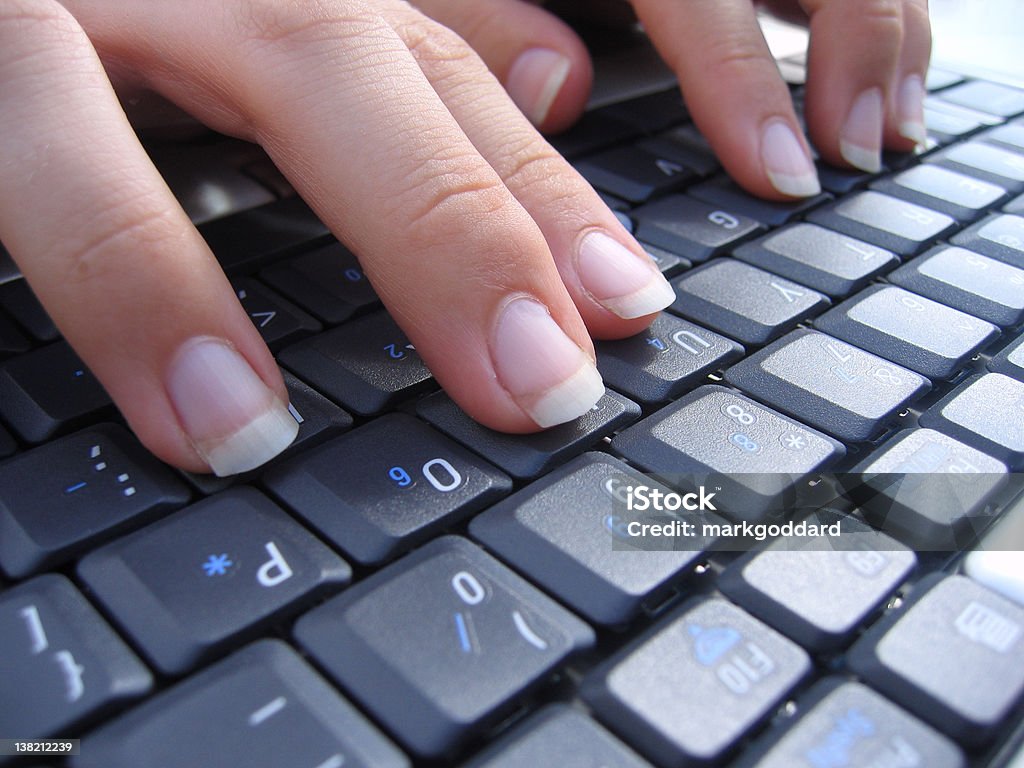 Typing on a Computer Keyboard (Close up) A woman's hands typing on a laptop. Adult Stock Photo