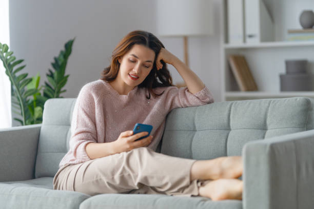 istock woman is using a phone sitting on a sofa 1382128504
