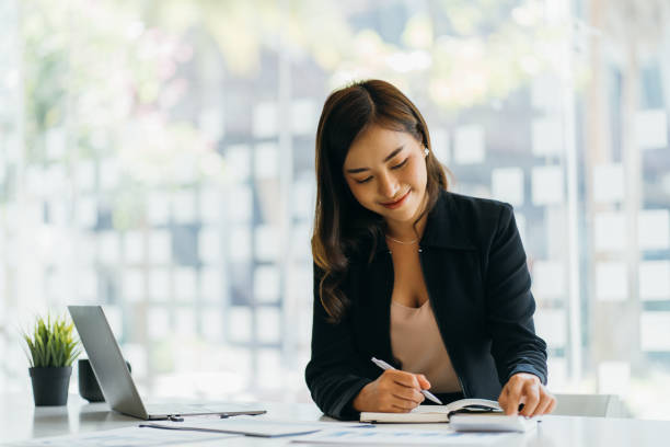 istock Asian business woman financial manager taking notes when working on report 1382130031