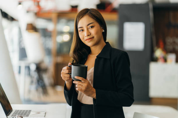 istock Young asian businesswoman on a coffee break and using laptop computer in office. 1382130331