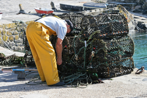 A fisherman prepares his nets and lobster pots.