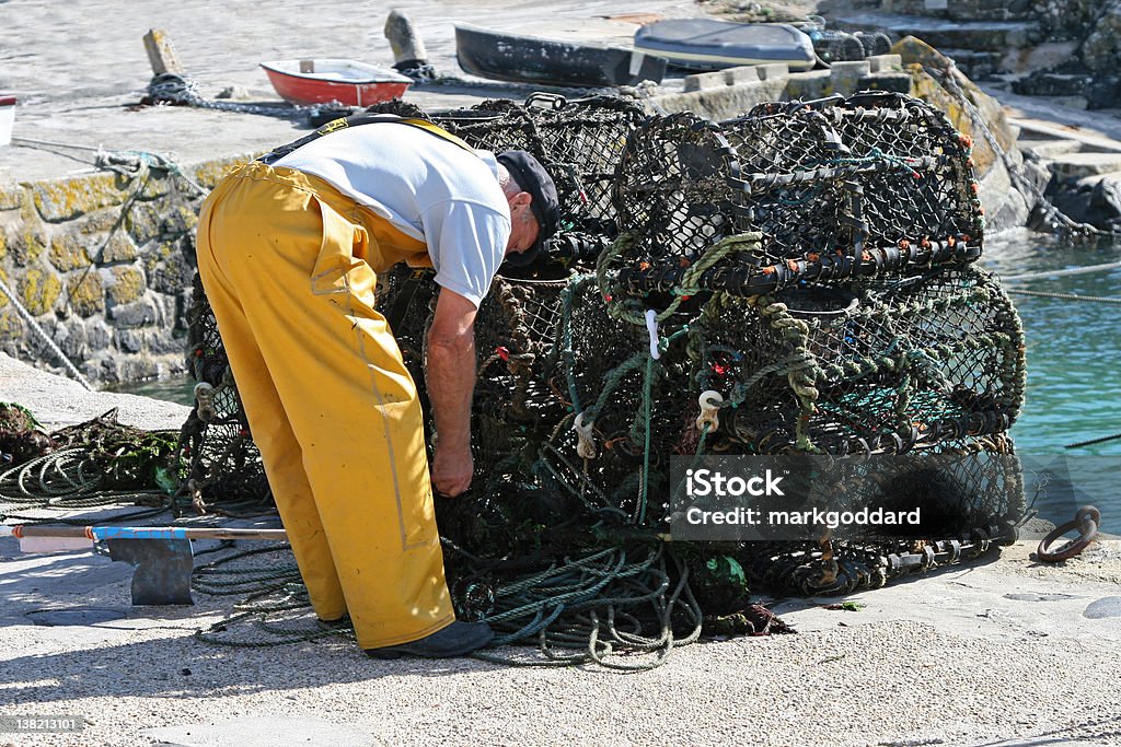 Fisherman preparar suas redes - Foto de stock de chapéu de oleado royalty-free