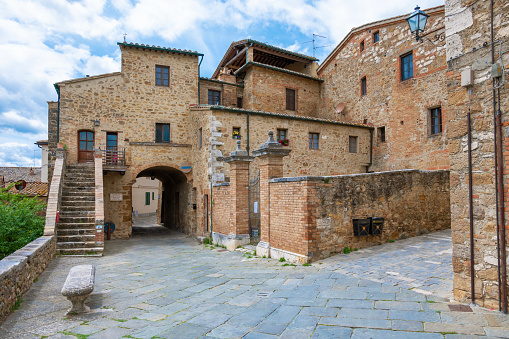 San Quirico d'Orcia, Italy - 15 May 2021 - The wonderful renaissance town of Tuscany region, during the spring, with historical center in stone and famous views in the Val d'Orcia landmark.  Here in particular an old building in stone