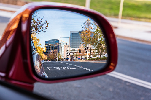 Beautiful modern city skyline from rear view mirror at dusk, Canberra, Australia.