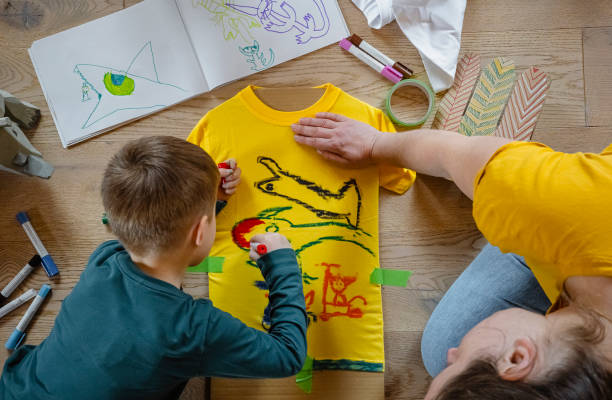 istock Young child drawing his own artwork on shirt at home 1382158207