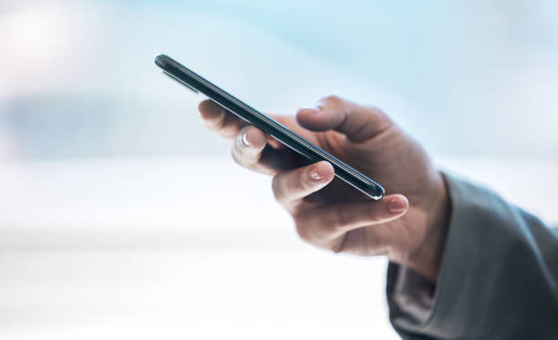 istock Cropped shot of an unrecognizable businessman using his cellphone while standing in the office 1382165333