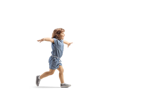 полнометражный профильный снимок счастливой маленькой девочки, бегущей и раздвигающей руки - scoring run стоковые фото и изображения