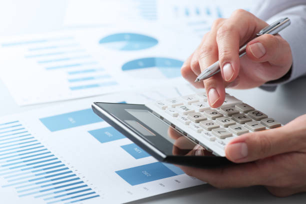 istock Financial analysis concept. Working with calculator. Close up of hands. 1382187740