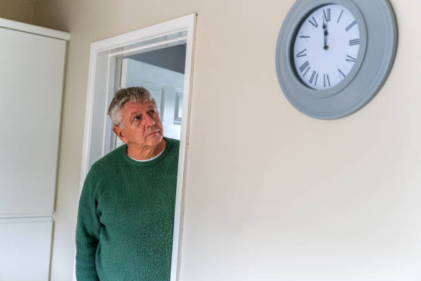 Senior Caucasian man peering around doorway