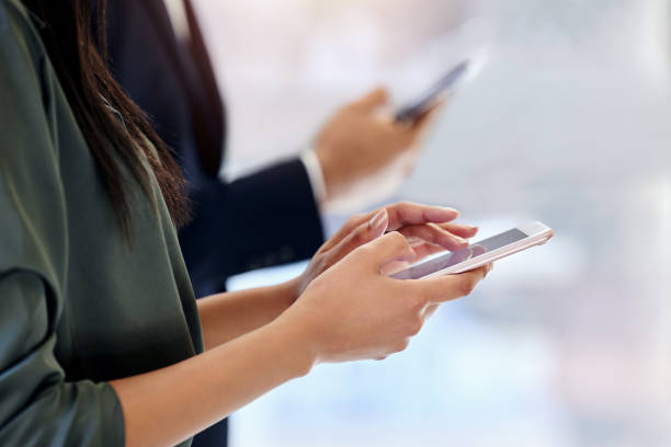 istock Shot of two unrecognizable businesspeople using their phones at work 1382192225