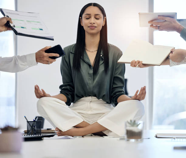 scatto di una giovane imprenditrice che medita su una scrivania in un ambiente di lavoro impegnativo - yoga meeting foto e immagini stock