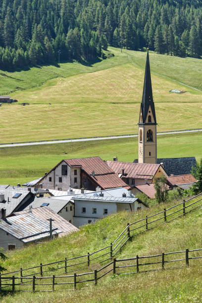 швейцарская альпийская деревня с колокольней реформистской церкви - engadine switzerland village church стоковые фото и изображения