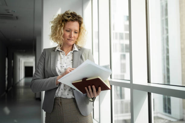 istock Focused Caucasian businesswoman looking at documents at the hall 1382205974