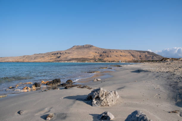 istock Empty sandy rocky beach in Greece with rough rock. Sea, sun, blue sky background. 1382242651