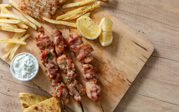 souvlaki dish, greek meat food. grilled chicken skewers and pita bread on wooden table, overhead - souvlaki imagens e fotografias de stock