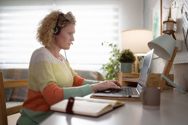 istock From home office, Caucasian female dispatcher working while using headset and laptop 1382262292