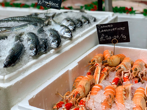 Cork, Ireland - 16 August, 2022: fishmonger market stall with fresh fish and seafood on ice inside the English Market in Cork