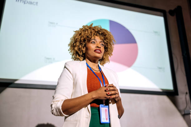 istock Casually clothed hipster woman holding a speech on a conference 1382268979